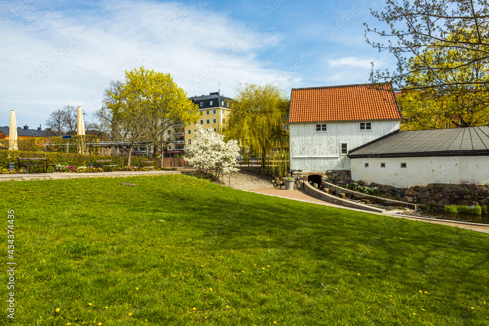 Beautiful landscape view. Old buildings surrounded of blooming trees on blue sky background. Sweden. Beautiful landscape view. Old buildings surrounded of blooming trees on blue sky background. Sweden.