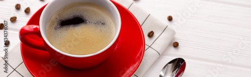 Coffee cup and coffee beans on white wooden background