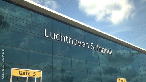 Taking off airplane reflecting in the modern windows with Luchthaven Schiphol or Airport Schiphol text photo