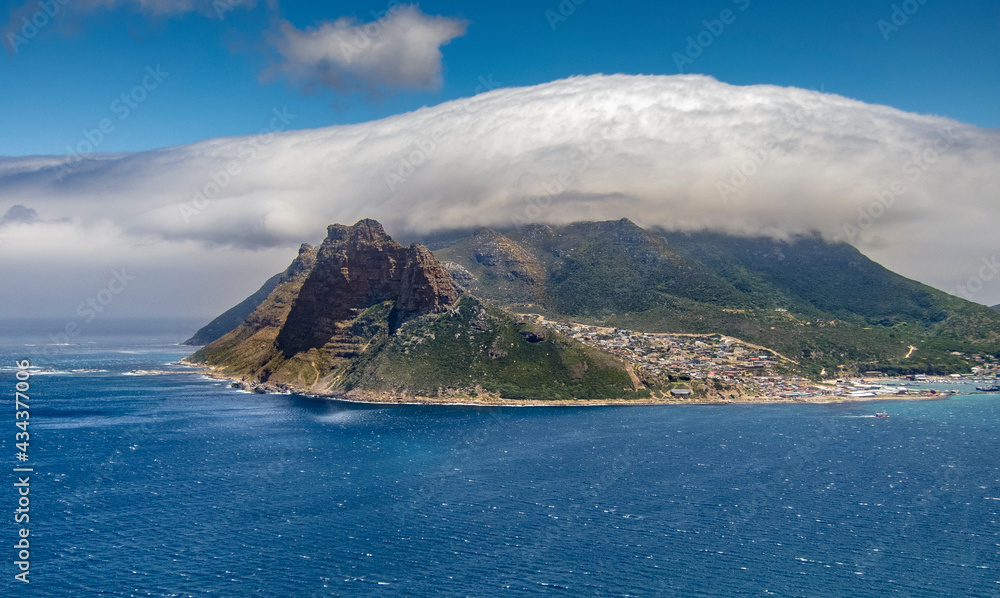 panaramic view on Hout Bay, the southern Harbor of Cape Town, with characteristic table cloth clouds rolling over the mountains,South Africa, landscape
