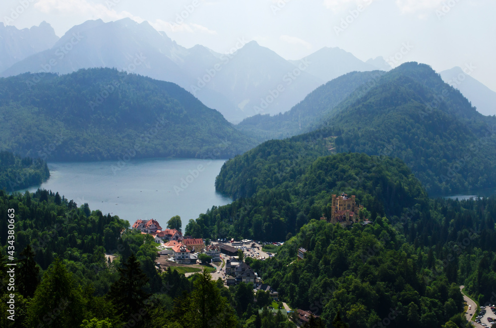 Misty day in the Bavarian Alps near Fussen, Germany. Alps and lakes in a summer day in Germany. Taken from the hill next to Neuschwanstein castle. View of the Hohenschwangau castle, Bavarian Alps