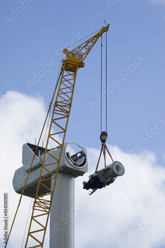 A crawler crane is hoisting the gearbox of a new wind turbine