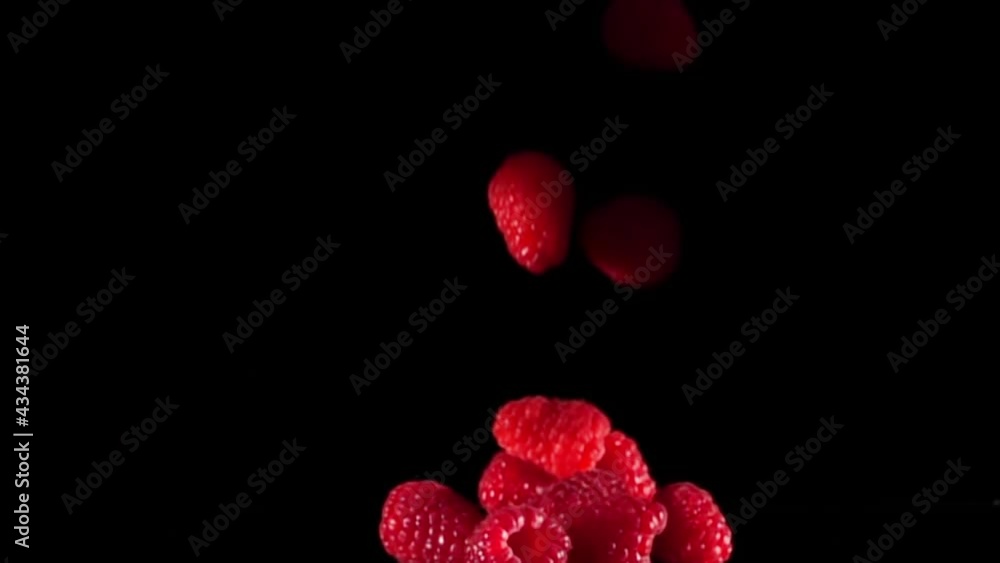 Fresh Raspberries Falling On Black Background In Slow Motion. Fresh Raspberries Falling On Black Background In Slow Motion.