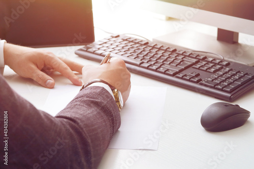 Young business man working at the computer and papers on the table