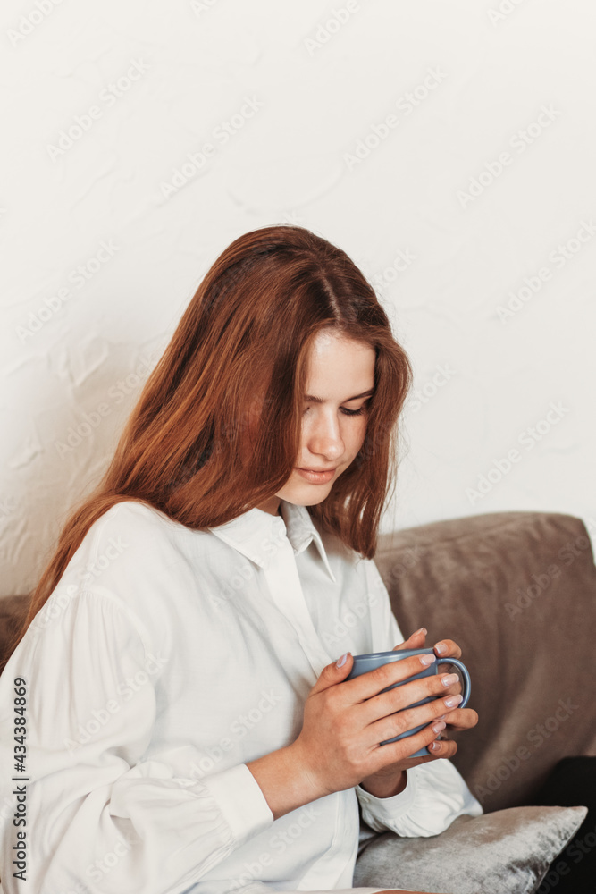 Portrait of a brooding beautiful girl with a cup of coffee in her hands Portrait of a brooding beautiful girl with a cup of coffee in her hands