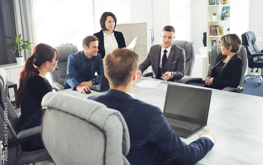 Group of young successful businessmen lawyers communicating together in a conference room while working on a project Group of young successful businessmen lawyers communicating together in a conference room while working on a project