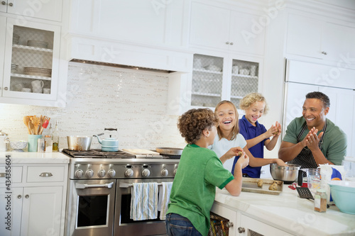 Happy family preparing cookies together in domestic kitchen