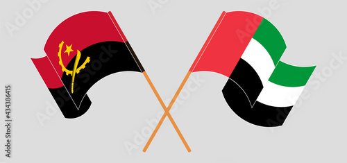 Crossed and waving flags of Angola and the United Arab Emirates