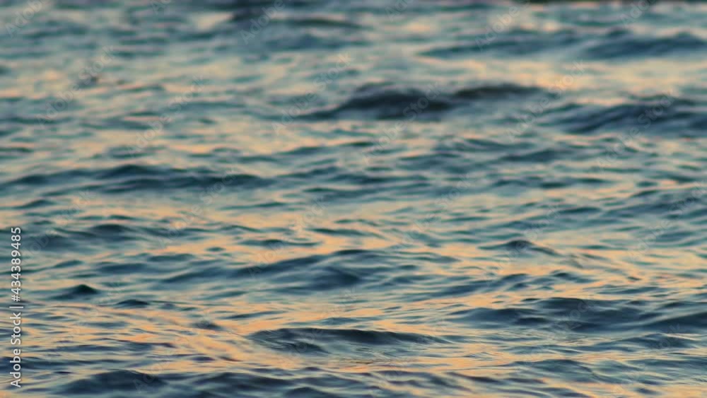 Sea, ocean surface with small waves and sunrise, sunset beams reflecting on the surface Sea, ocean surface with small waves and sunrise, sunset beams reflecting on the surface