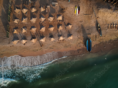 Aerial view of amazing beach with umbrellas and turquoise sea at sunrise. Black Sea at Vama Veche, Romania photo