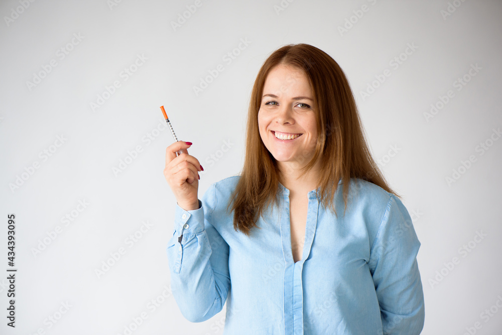 Woman with an insulin syringe isolated on white background- concept of diabetes. Woman with an insulin syringe isolated on white background- concept of diabetes.