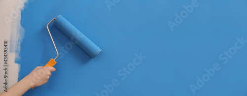 Fotografie Woman painting wall with roller, closeup. Redecoration