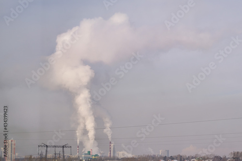 The pipes of the plant are smoking. Air pollution. Take care of nature. Take care of the environment.