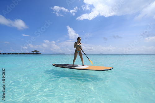 SUP surfing girl in Maldives