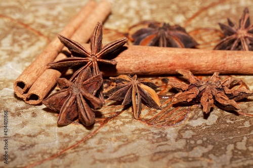 Star anise and cinnamon sticks on a brown background