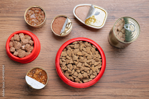 Wet and dry pet food on wooden table, flat lay