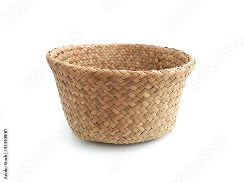 Frontal view of Braided storage basket isolated. Close up of Old plaited empty round wicker basket. Natural fiber basket on white background. Accessories and Household equipment. Brown bamboo bowl.
