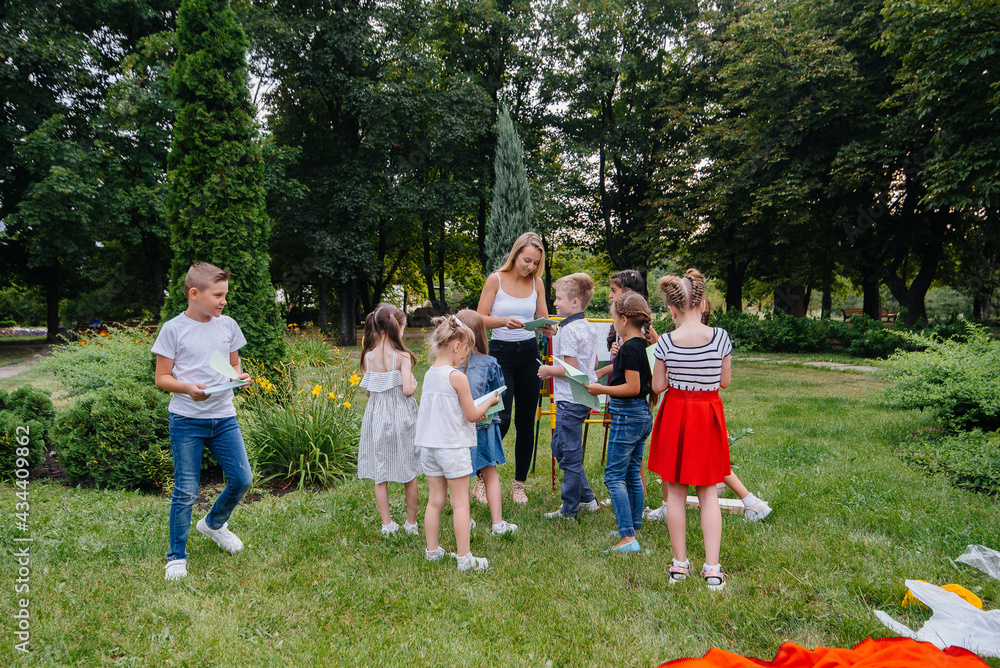 Obraz premium A teacher teaches a class of children in an outdoor Park. Back to school, learning during the pandemic