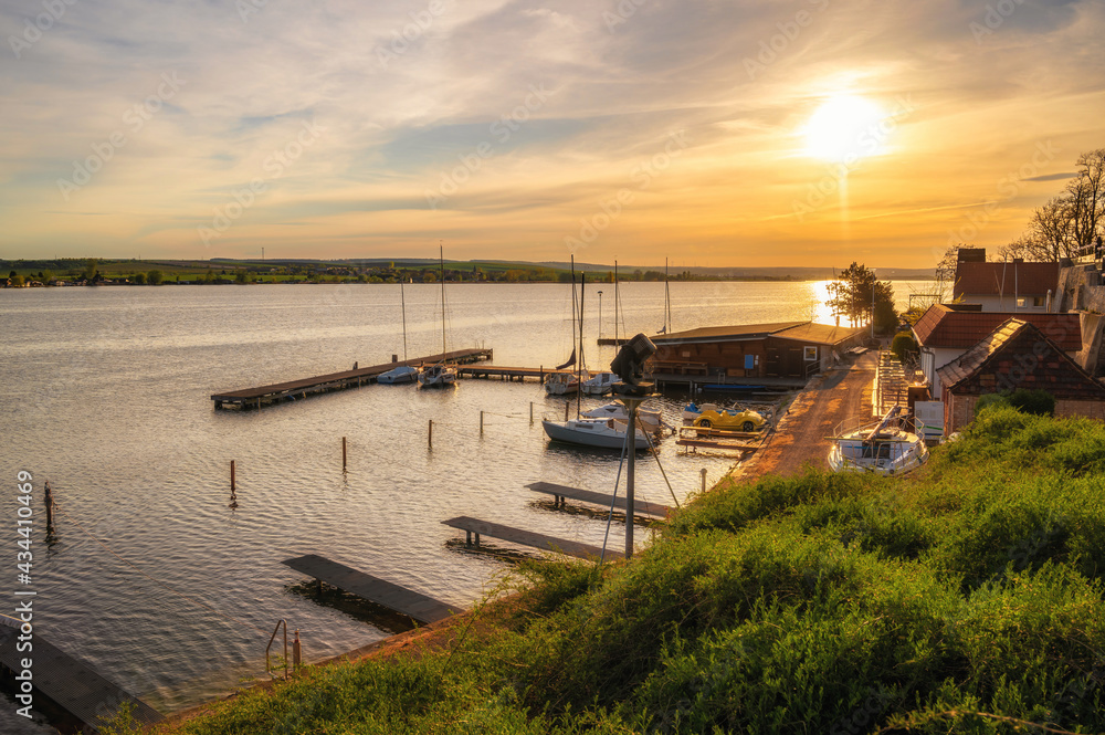 Blick über den Bootssteg am Schloss Seeburg am Süßen See bei Sonnenuntergang