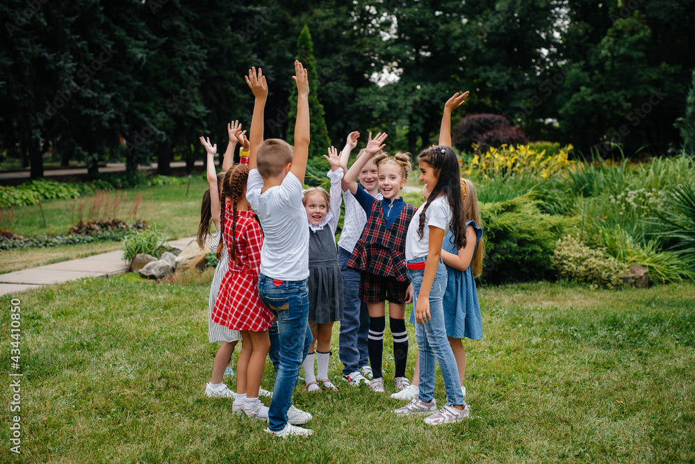 Fototapeta premium A group of children run around, have fun and play as a larger team in the summer in the Park. Happy childhood
