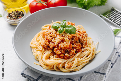 Traditional italian pasta spaghetti with bolognese meat sauce and parmesan on a white concrete, stone table background. Close up