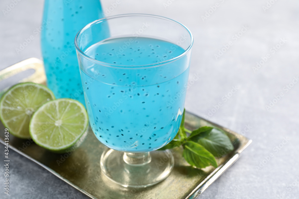 Tasty light blue drink with basil seeds on grey table Tasty light blue drink with basil seeds on grey table