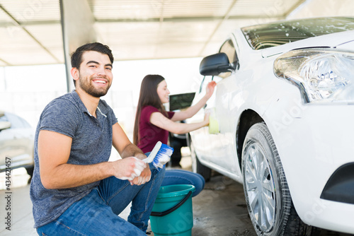 Boyfriend helping to wash his girlfriend's car