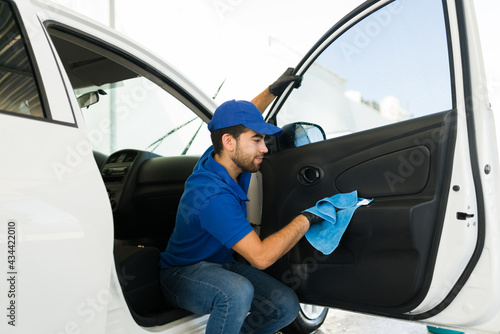 Hispanic young man working at the auto detail service