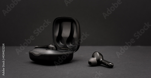Plakat Blank wireless bluetooth earphones on black background