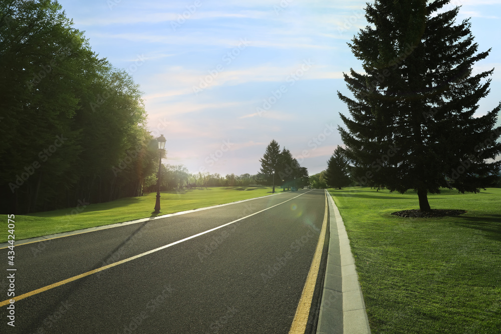 Beautiful view of empty asphalt road and green trees on sunny day Beautiful view of empty asphalt road and green trees on sunny day