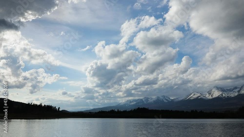 Lake and public beach near Svit, Slovakia. Spring windy day. Green forest and High Tatras mountains in background.