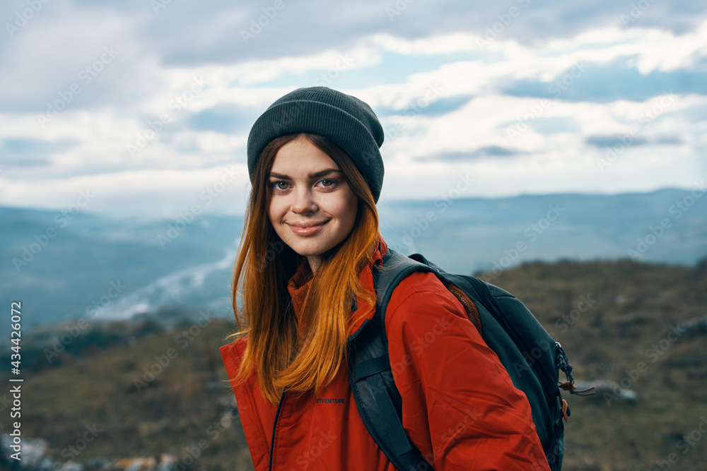 portrait of a woman in warm clothes in the mountains in autumn landscape tourism