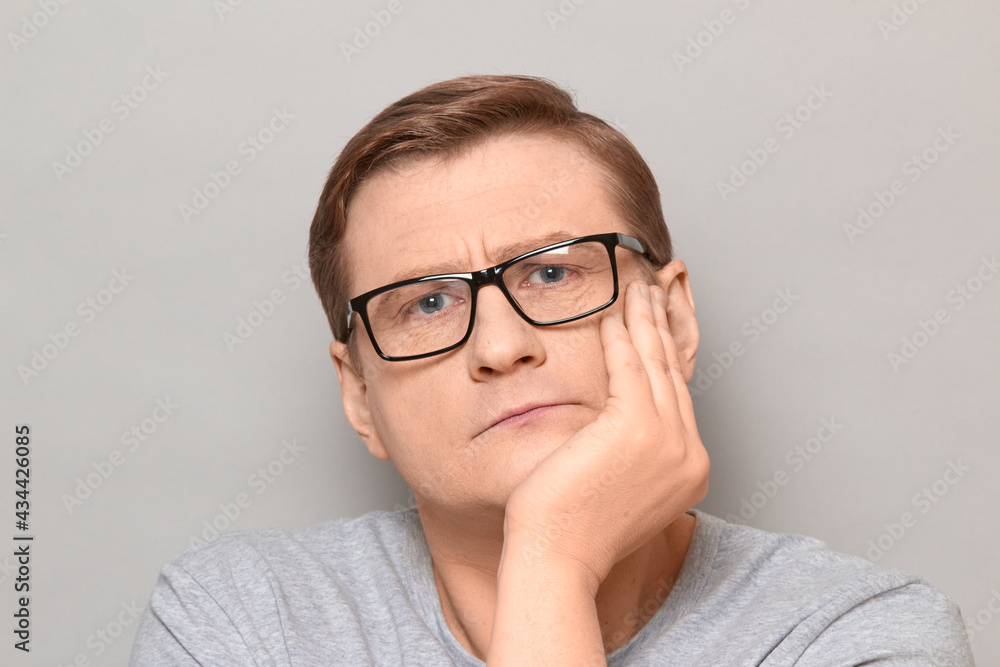 Portrait of serious mature man propping head with hand Portrait of serious mature man propping head with hand