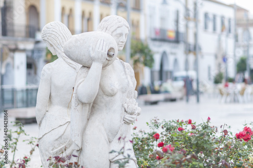 Closeup of statues of women in a park with buildings in the background in Ecija, Spain photo