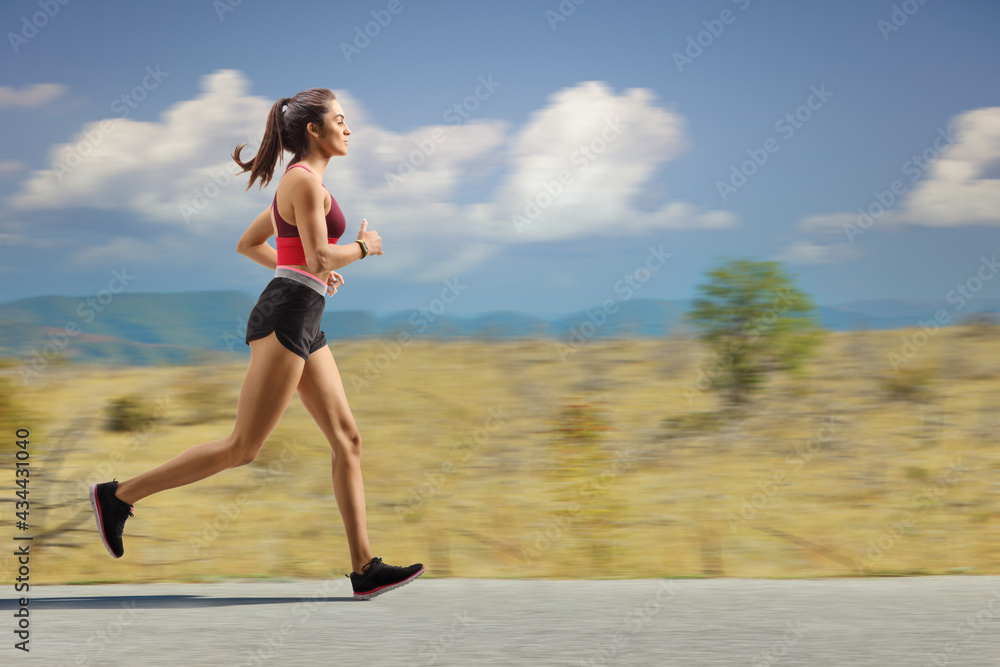 Female athlete jogging outdoors on an open road