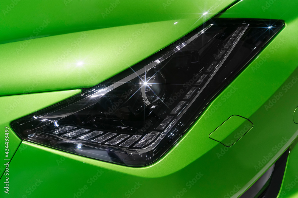 Φωτογραφία Headlight of sports car with sparkling stars, hood, fender and bumper details of