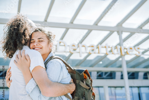 Lovely young couple hugging at the airport departures