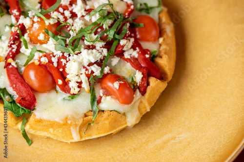 Waffle with tomato, basil, mozzarella, roasted bell peppers, and feta cheese.