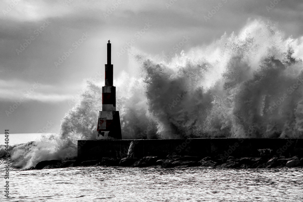 Giant waves breaking on the breakwater and the lighthouse