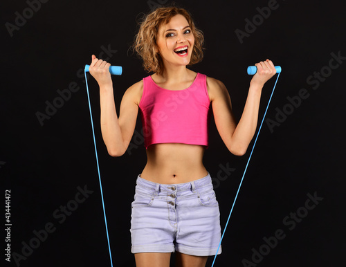 Fitness Woman with jumping rope. Smiling sportive girl with skipping rope.