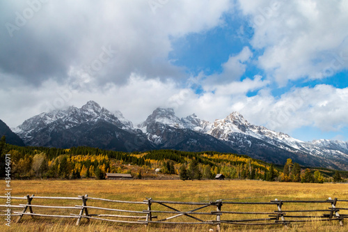 dramatic snow capped mountain peaks of the Grand teton mountain range and colorful autumn foliage in Jackson, Wyoming.