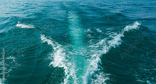 Rear view from ship to blue sea with waves and foam. © bluebeat76
