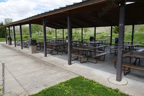 Modern public park shelter house with several picnic tables