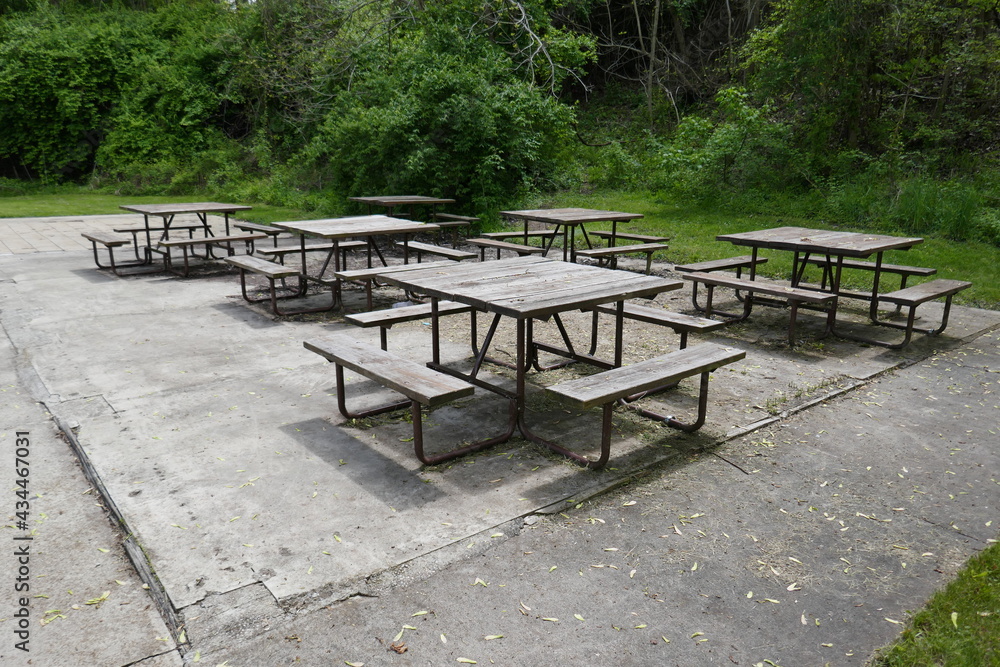 Empty square picnic tables on concrete patio outdoors Empty square picnic tables on concrete patio outdoors