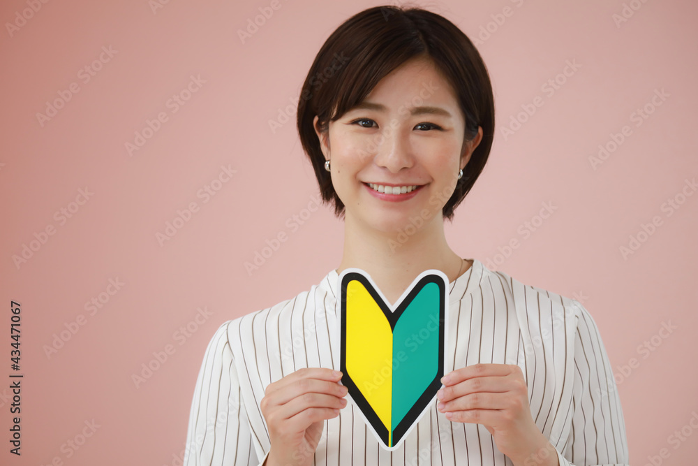 初心者マークを持つ女性 初心者マークを持つ女性