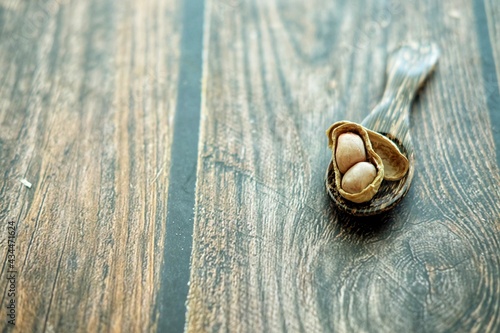 Peanuts on wooden spoon.