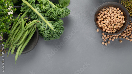 Assorted green vegetables and cereal on gray background. Healthy food concept.