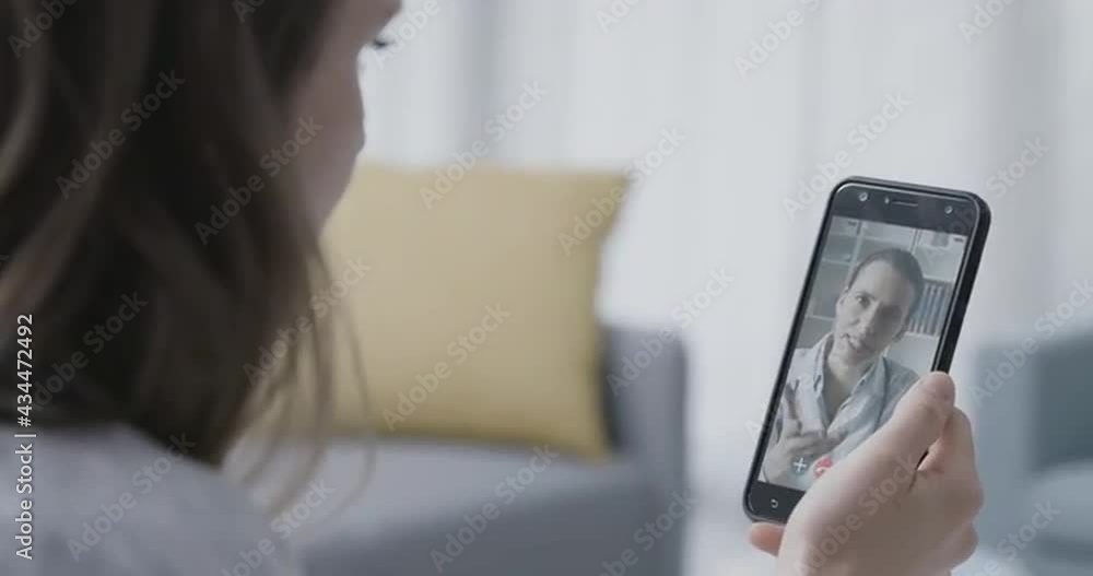 Woman video calling her online doctor Woman video calling her online doctor