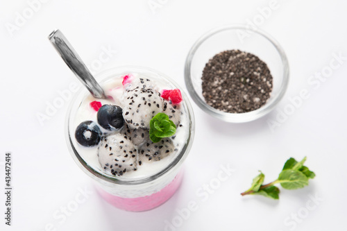 Layered chia puding with pink filling on white background.