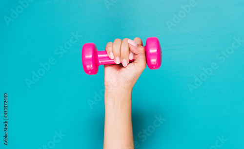 Closeup of hand holding a pink dumbbell